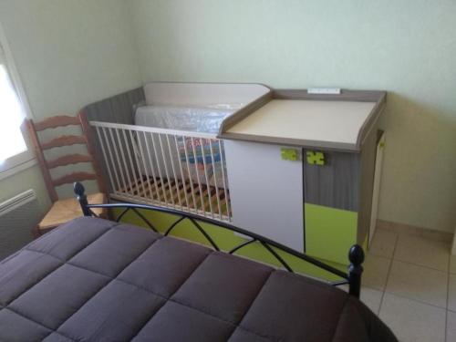 une petite chambre avec un lit et une cage dans l'établissement La Maison du Guilhaumard, à Cornus