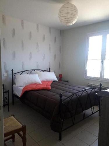 une chambre avec un grand lit avec une couverture rouge dans l'établissement La Maison du Guilhaumard, à Cornus