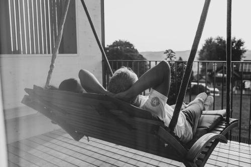 a man and a woman laying in a hammock at Stock & Stein Lodges in Bad Gleichenberg