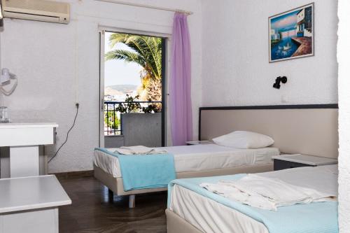 a hotel room with two beds and a window at Gorgona Hotel in Amoudara Herakliou