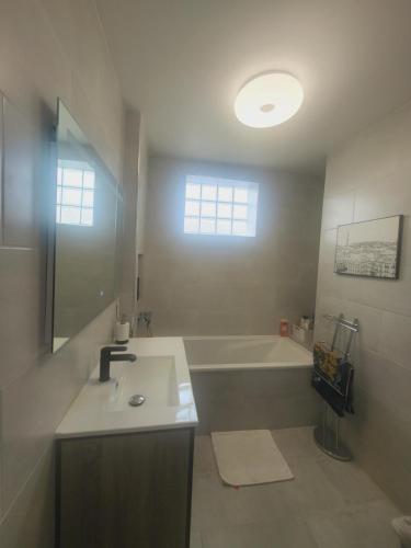 y baño con lavabo y bañera. en Homestay - Large Room in a Spacious Apartment with Stunning Rooftop Terrace en Châtenay-Malabry
