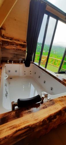 a bath tub in a room with a large window at Ömra bungalov in Pazar