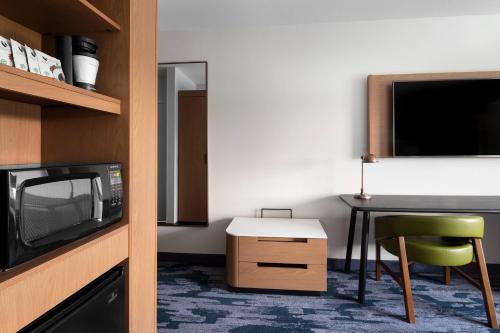 a room with a microwave and a table with a chair at Fairfield Inn & Suites by Marriott Kenosha Pleasant Prairie in Pleasant Prairie