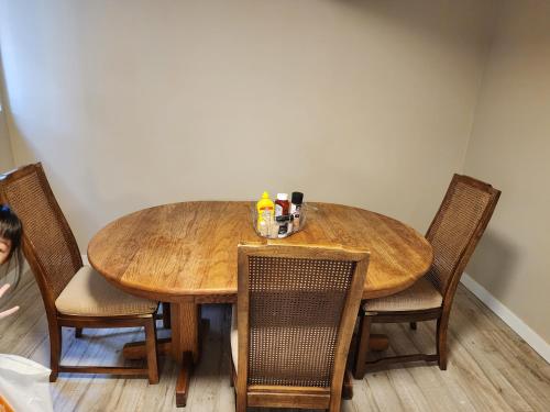 uma mesa de jantar com cadeiras e uma mesa de madeira em Economical Homestay em Burnaby