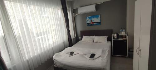 ein kleines Schlafzimmer mit einem Bett mit weißer Bettwäsche und einem Fenster in der Unterkunft THE LİMA SUİTES KADIKÖY in Istanbul