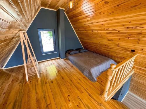 Zimmer mit einem Bett und einer Treppe in einer Hütte in der Unterkunft BULUT BUNGALOW in Akcaabat