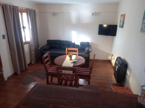 sala de estar con mesa, sillas y sofá en Departamento San Martin de los Andes Zona Centro en San Martín de los Andes
