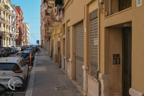 una calle de la ciudad con coches y edificios aparcados en CAOS en Bari
