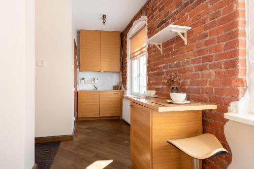 a kitchen with a brick wall and a counter at Rüütli Apartments in Tartu Old Town in Tartu