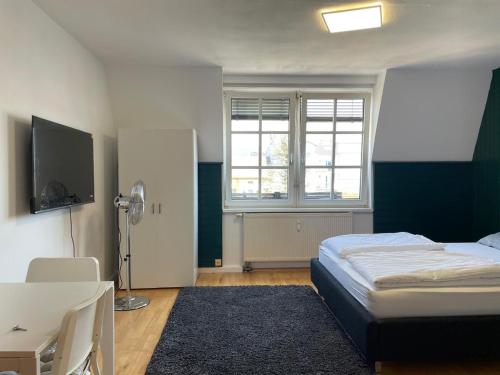 1 dormitorio con 1 cama, escritorio y TV en Linz -central condo, en Linz