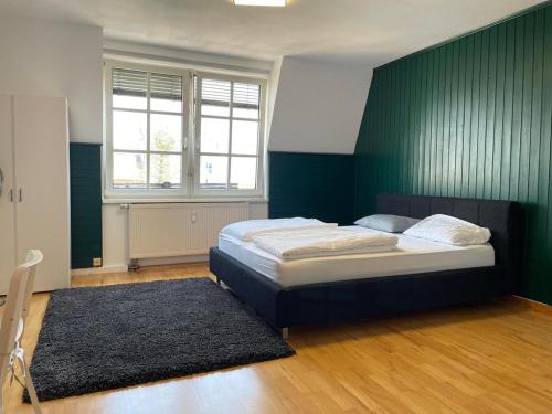 1 dormitorio con cama y pared verde en Linz -central condo, en Linz