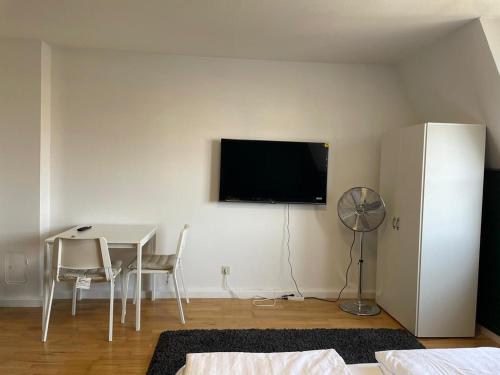 a living room with a table and a television on the wall at Linz -central condo in Linz