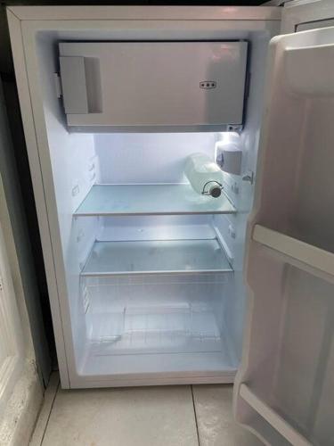 un réfrigérateur vide avec sa porte ouverte dans une cuisine dans l'établissement Bandol plage, resto et port à 1min, à Bandol