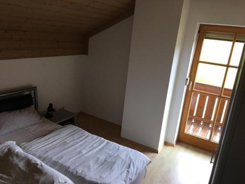 1 dormitorio con 1 cama y puerta abierta en FeWo Tannerbauer en Regen