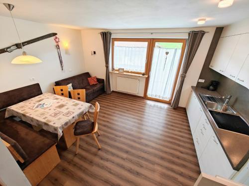 a kitchen and a living room with a table at Apartments Brunella in La Villa