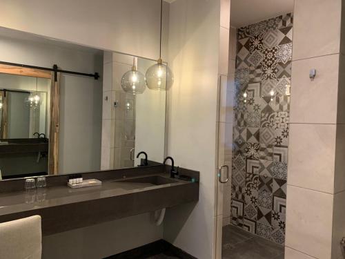 y baño con lavabo y espejo. en Hotel Partana, en Ensenada