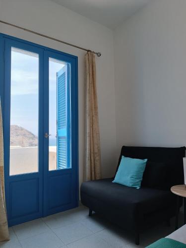 a living room with a blue door and a couch at Thea Nisaki Mochlos in Mochlos