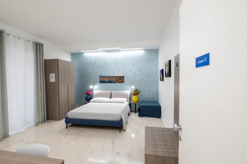 een slaapkamer met een bed en een blauwe muur bij B&B BISCEGLIE in Bisceglie