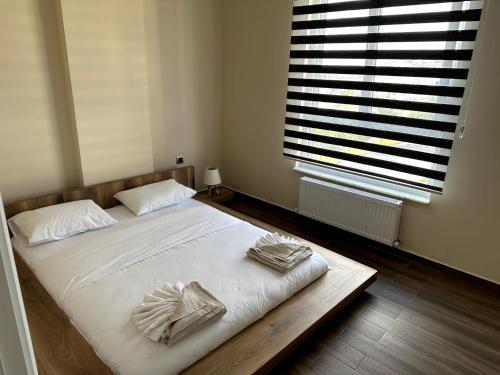 a bedroom with a bed with white sheets and a window at THE SUİT Residence in Nevsehir