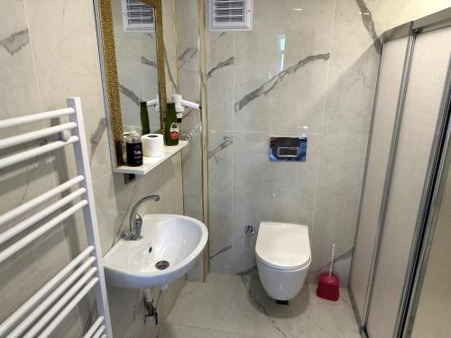uma casa de banho branca com um lavatório e um WC em THE SUİT Residence em Nevşehir