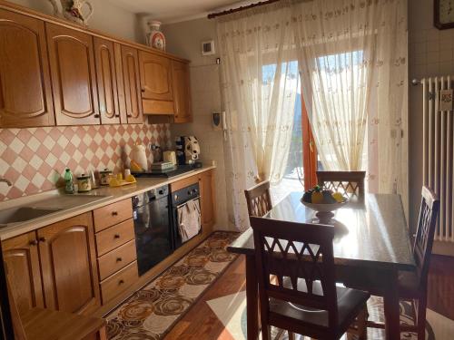 uma cozinha com armários de madeira e uma mesa com cadeiras em B&B Michela em Baronissi