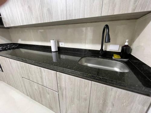a kitchen sink with a black counter top at Yari-Amazing Apartment MED in Medellín