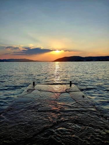 a boat in the water with the sunset in the background at Mary's Luxury Apartment in Agria
