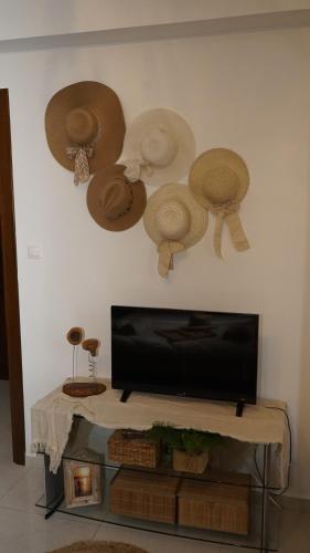 a room with a tv and hats on the wall at Mary's Luxury Apartment in Agria