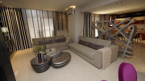 a living room with a couch and a table at Mary's Luxury Apartment in Agria