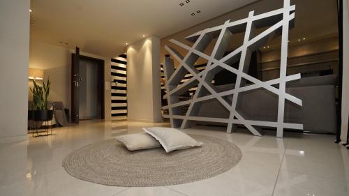 a living room with a rug on the floor and a staircase at Mary's Luxury Apartment in Agria