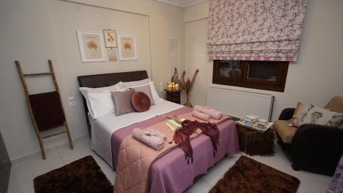a bedroom with a bed with two ottomans at Mary's Luxury Apartment in Agria