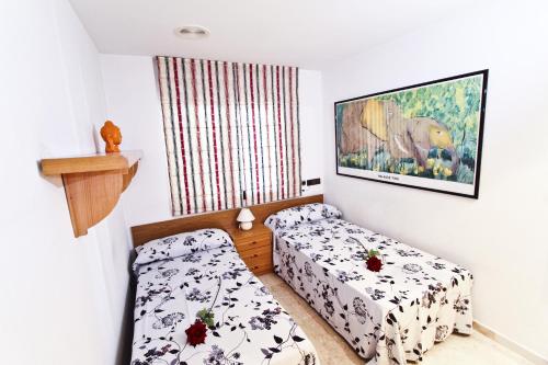 a room with two beds and a picture on the wall at Eva Vendrell Planet Costa Dorada in Salou