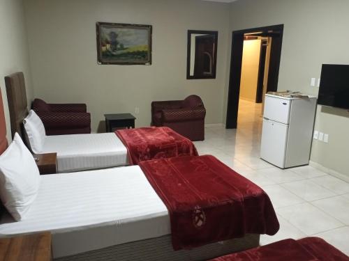 um quarto de hotel com duas camas e duas cadeiras em ورده em Al Khobar