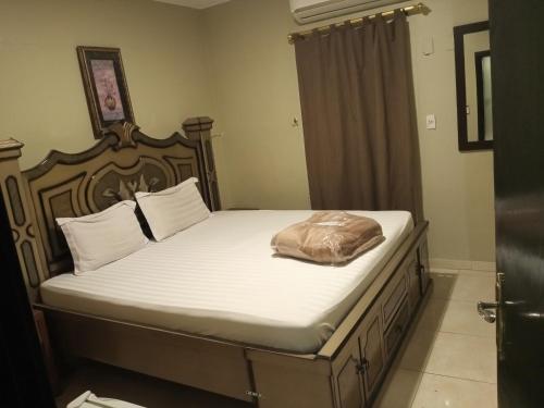 uma cama com uma estrutura de madeira com uma almofada em ورده em Al Khobar