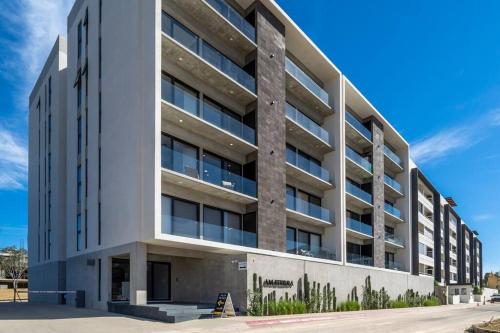 a large white building with a lot of windows at Casa Sueño - Modern, spacious & luxurious brand new condo in Cabo San Lucas