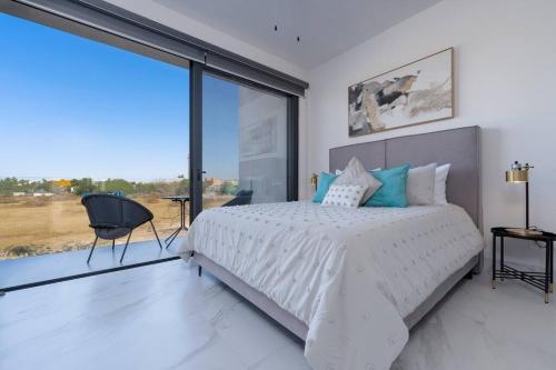 a bedroom with a white bed and a large window at Casa Sueño - Modern, spacious & luxurious brand new condo in Cabo San Lucas