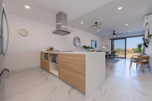 a kitchen with white walls and a stove top oven at Casa Sueño - Modern, spacious & luxurious brand new condo in Cabo San Lucas