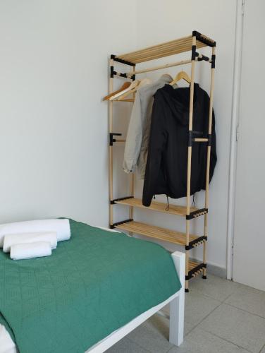 a room with a bed and a rack with clothes at Thea Nisaki Mochlos in Mochlos