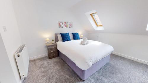 a white bedroom with a large bed with blue pillows at Blakelock House Hartlepool Horizon Stays in Hartlepool
