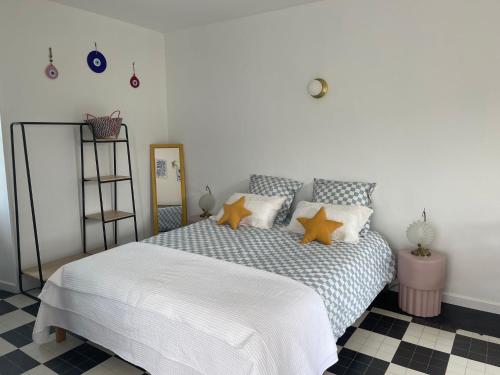 a bedroom with a white bed with orange pillows at Venez Vernou 