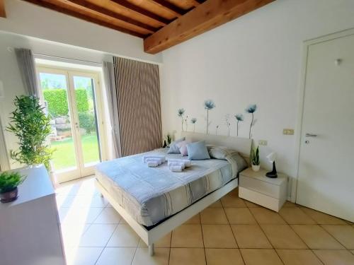 a bedroom with a large bed and a large window at Corte dei sogni - Mountain and Lake in Ranzanico