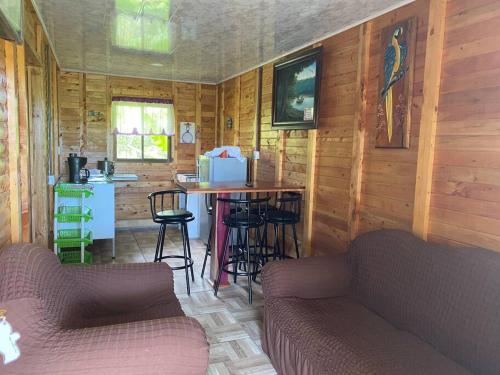 una habitación con mesa y sillas en una cabaña en La Mochis, en Puerto Jiménez