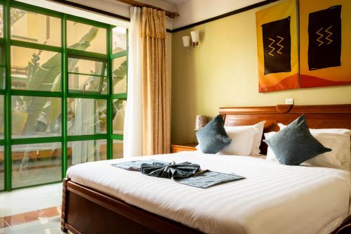una camera da letto con un letto con un arco sopra di Highlands Suites Hotel and Apartments a Kigali