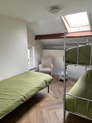 um quarto com 2 beliches e uma cadeira em Gastenverblijf Stekkenhof em Haalderen