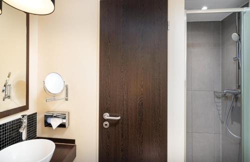 a bathroom with a toilet and a wooden door at Leonardo Hotel Berlin in Berlin