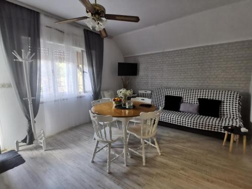 ein Wohnzimmer mit einem Tisch und einem Sofa in der Unterkunft Vikendica pod kulom in Vršac