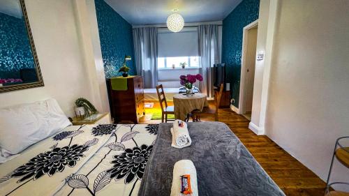 a hotel room with a bed and a table at Lovely flat near train station and central london in London