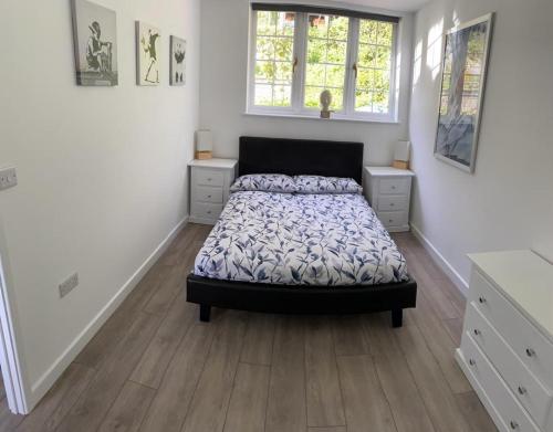 a bedroom with a bed and two windows at Sylvan Seas in Whitwell