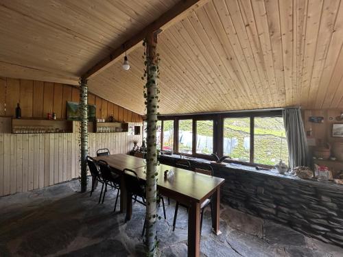 a dining room with a wooden table and chairs at Shio's Stonehouse in Tusheti in Tusheti