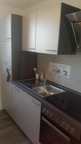a small kitchen with a sink and a stove at FeWo Nordsee Whng 2 in Wangerland